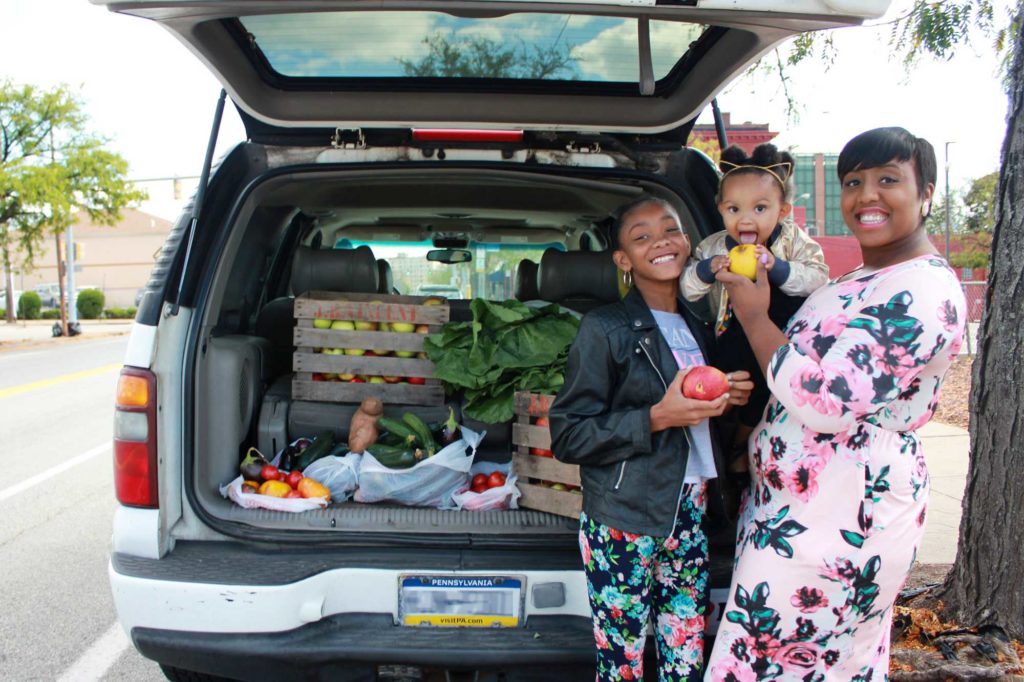 Woman and two children with a car load of rescued food